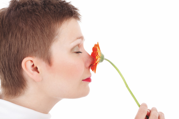 femme sentant une fleur